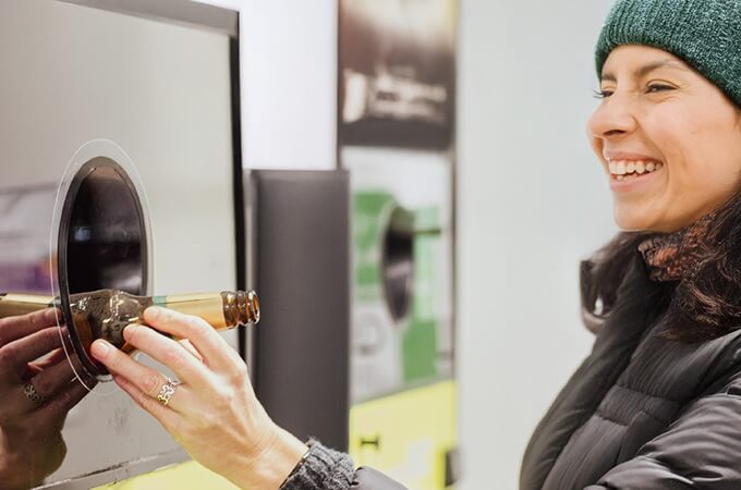 Person Recycling a Glass Bottle